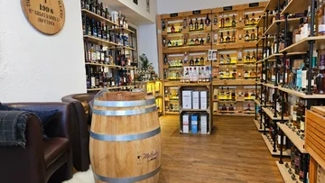 Whiskeyladen mit Regalen und Fass, gemütliches Interieur.