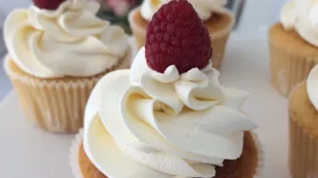 Vanillecupcakes mit Himbeeren, cremiges Frosting.