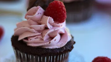 Schokoladen-Muffin mit rosa Glasur, Himbeer-Dekor.