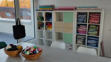 Craft room with yarn, fabrics, and storage.