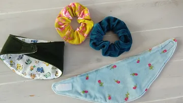 Zwei Bandanas und zwei Scrunchies auf Holzoberfläche.