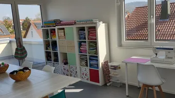 Craft room with shelves and sewing machine.