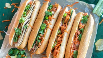 Vier Banh-Mi-Sandwiches auf Backpapier.