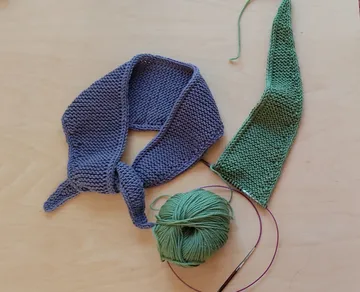 Knit scarves on a wooden table.