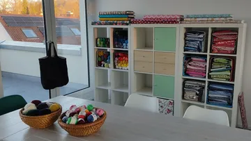 Craft room with yarn, fabric, large window.