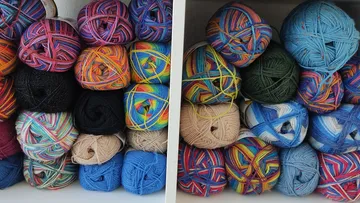 Colorful yarn balls stacked on shelves.