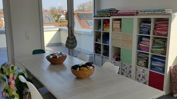 Craft room with table and organized supplies.