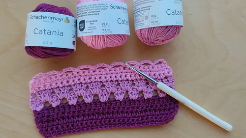 Häkelprojekt mit Garn und Haken auf Tisch.