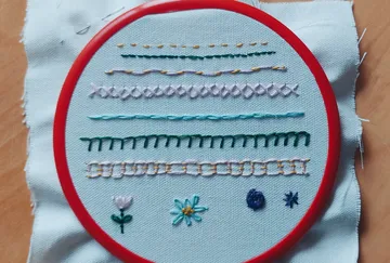 Embroidery hoop with colorful stitch samples.