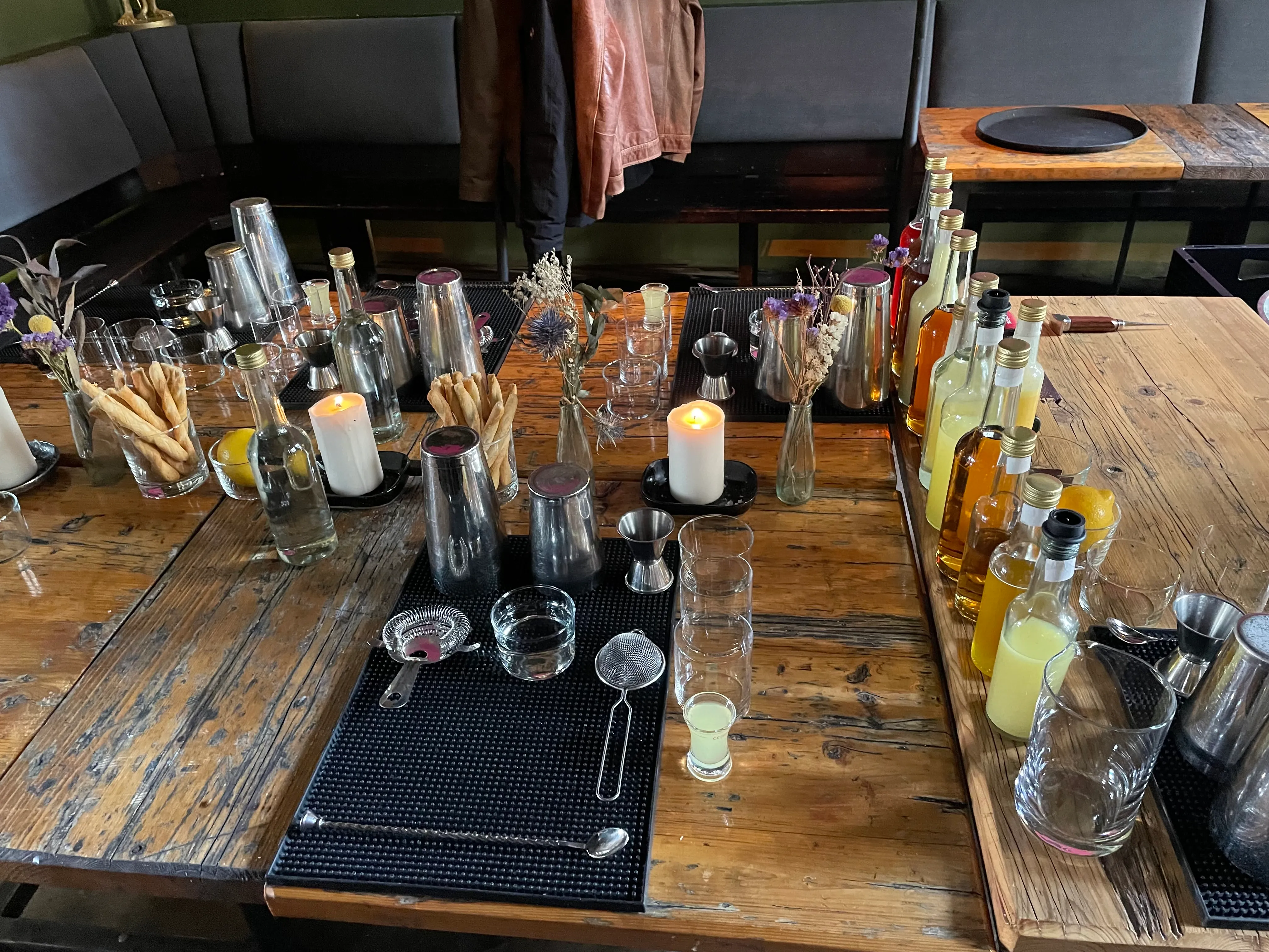 Table with bottles, glasses, and cocktail tools.