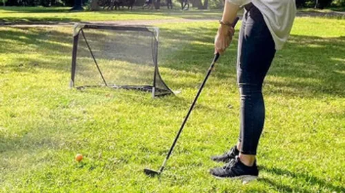 Person playing golf in a park.