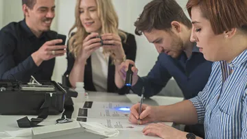 Group solving a puzzle with clues on table.