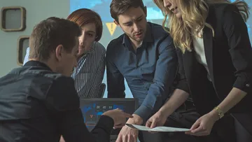 Gruppe diskutiert Dokumente im Büro.