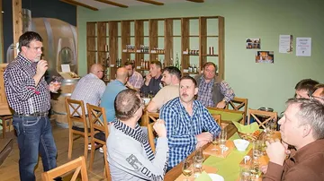 Men drinking whiskey in a tasting room.