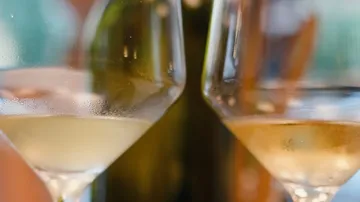 Two white wine glasses on a table.