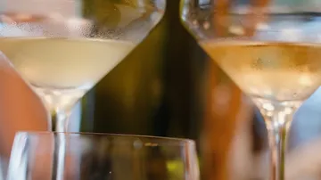 Two wine glasses filled with white wine.