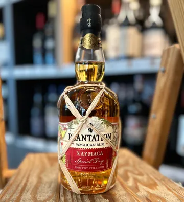 Rumflasche auf Holzoberfläche, unscharfer Hintergrund.