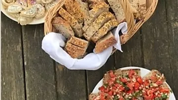 Bread, bruschetta, and rolls on wooden table.