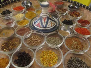 A handmade clay pot surrounded by spices.