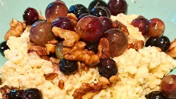 Porridge mit Trauben und Walnüssen belegt.