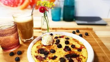 Pancake with blueberries and cream on table.