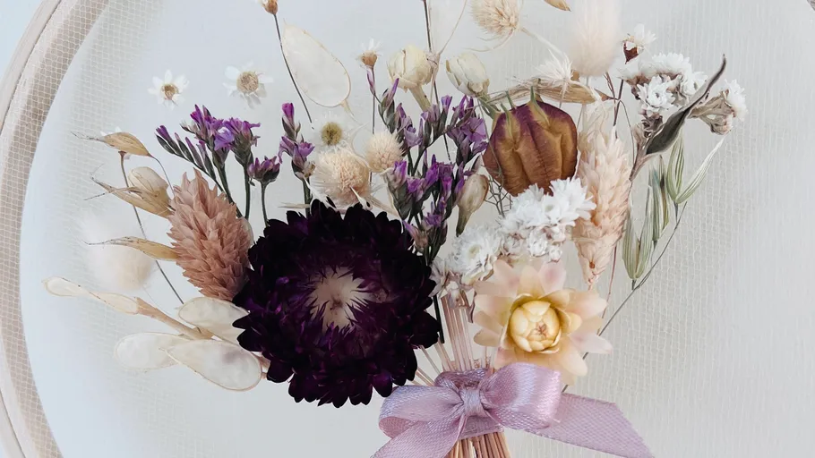 Dried flower bouquet with purple ribbon.