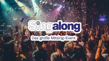 Crowd cheering under colorful confetti at concert.
