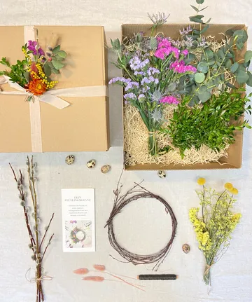 Craft kit with flowers, eggs, and wreath-making items.