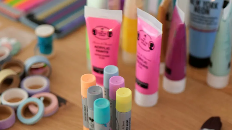 Acrylic paints and markers on table.