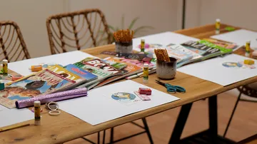 Bastelmaterial und Zeitschriften auf Holztisch.