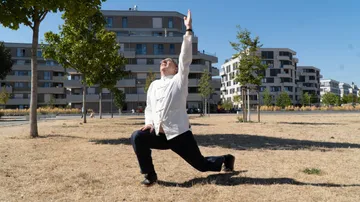Person practicing yoga in a sunny park.