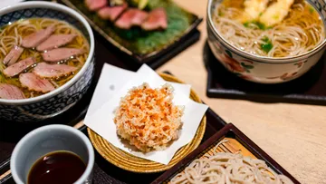 Japanese noodle dishes with tempura and sauce.