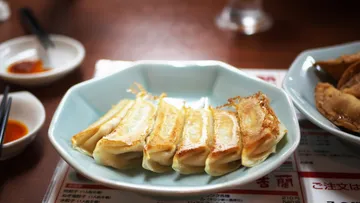 Fried dumplings on a plate, restaurant setting.