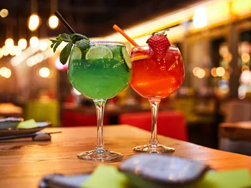 Two cocktails are sitting on a table in a restaurant.