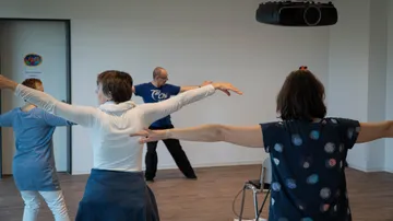 People practicing Tai Chi in a room.