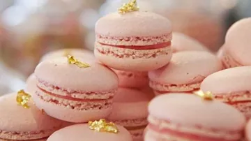 Pink macarons with gold leaf decoration.