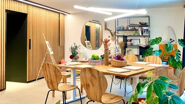 Creative workspace with wooden chairs and plants.
