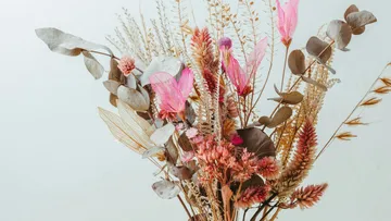 Dried floral arrangement with pink accents.