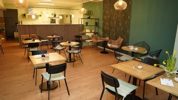 Cozy cafe with wooden tables and chairs.