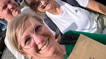 Drei lächelnde Personen im sonnigen Freien.