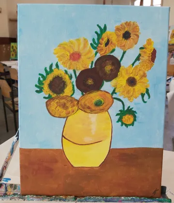 Painting of sunflowers in a yellow vase.