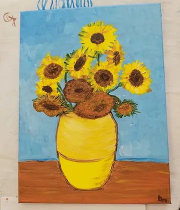 Sonnenblumen in gelber Vase, blauer Hintergrund.