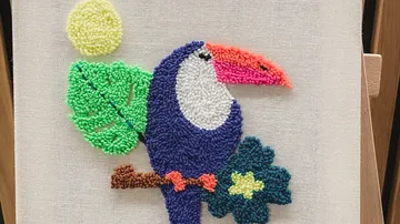Colorful toucan punch needle art on canvas.