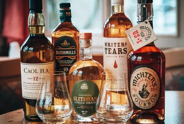 Whiskeyflaschen und Gläser auf einem Tisch.