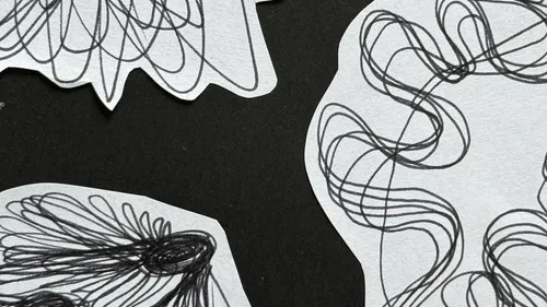 Abstrakte schwarze Kritzeleien auf weißem Papier.