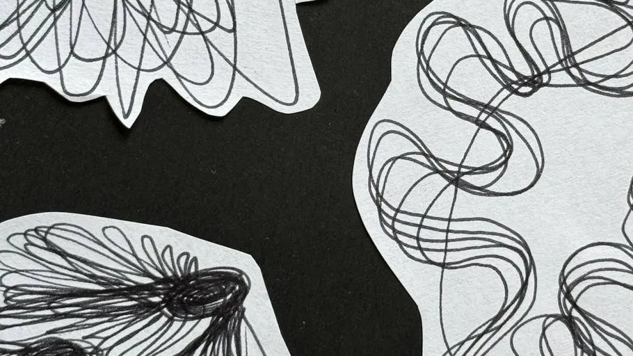Abstrakte schwarze Kritzeleien auf weißem Papier.