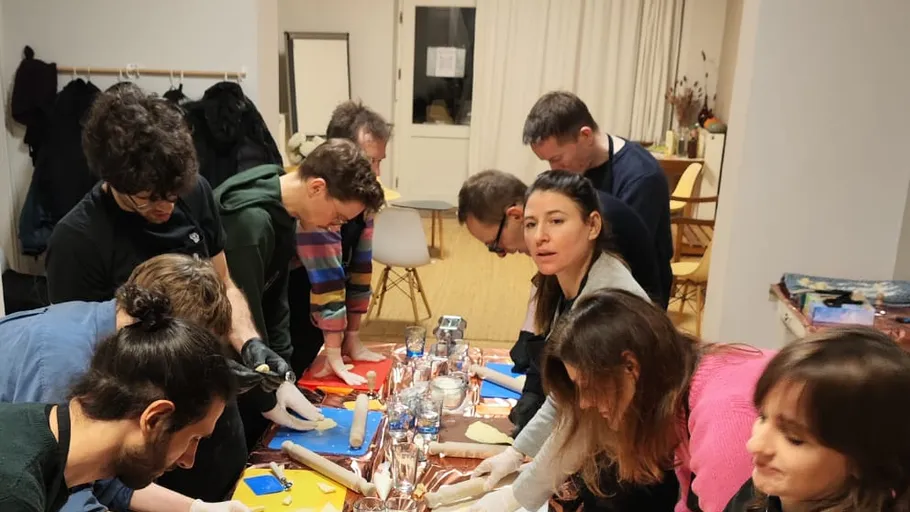 People making crafts around a table indoors.