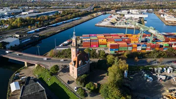 Uhrturm nahe Hafen mit Containern.