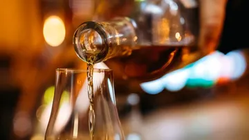 Liquor pouring from bottle into glass.