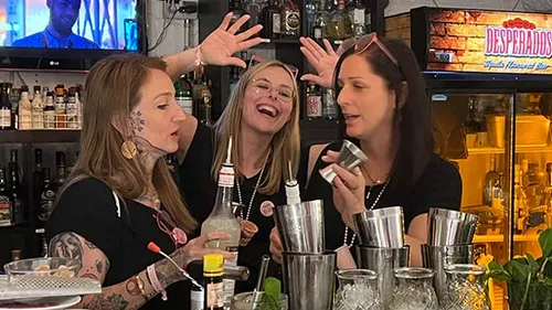 People making cocktails in a bar setting.